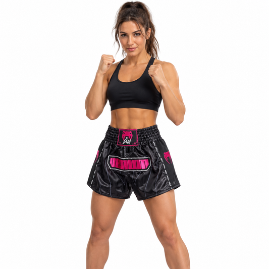 Female model wearing black and pink Venum Muay Thai shorts